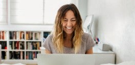 Image of woman smiling looking at laptop