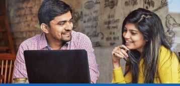 Deux jeunes actifs discutant devant un ordinateur portable