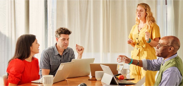 Team meeting with laptops and discussion