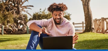 Une personne utilisant son ordinateur portable à l’extérieur.