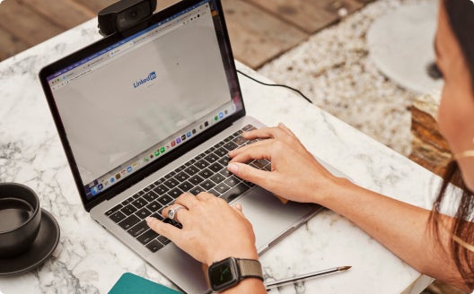 An individual working on their laptop inside.