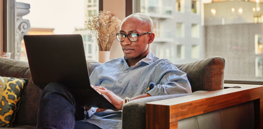 Person sitting on a couch working on a laptop