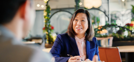 Person sitting at a table speaking to someone